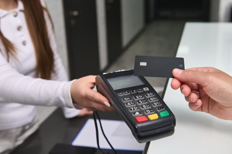 image of a man tapping to pay at a credit card terminal held by a woman